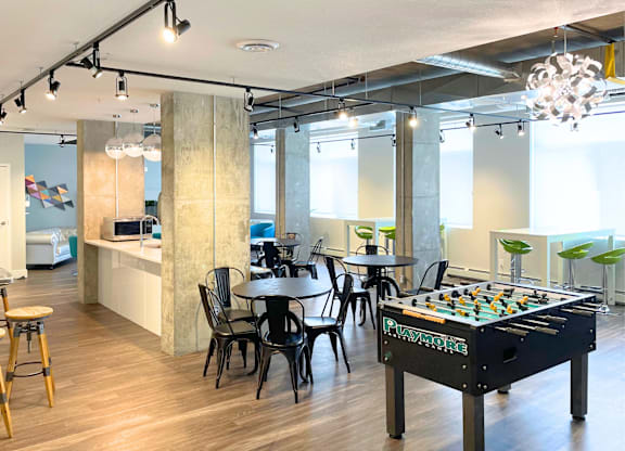 A room with a pool table and a bar area.