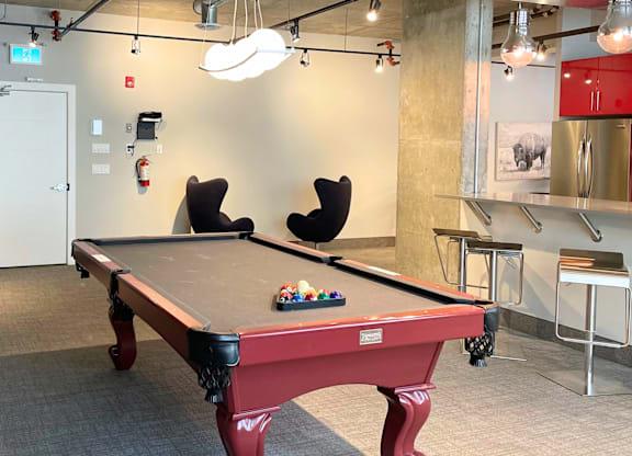 A pool table in a room with a red cloth and balls on it.