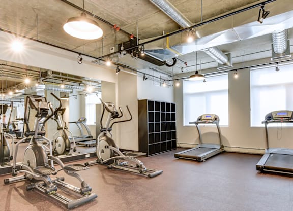 A gym with treadmills, elliptical machines, and other exercise equipment.