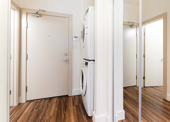A white washing machine is in a small laundry room.
