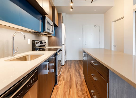 A kitchen with wooden floors and a white counter top.