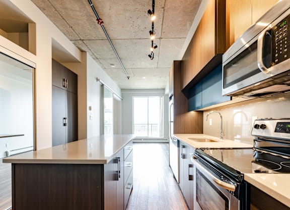A modern kitchen with dark wood cabinets and stainless steel appliances.