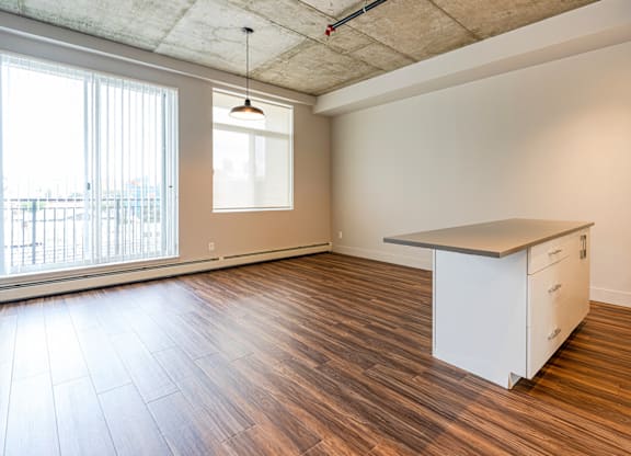 A room with a white cabinet and a window with blinds.