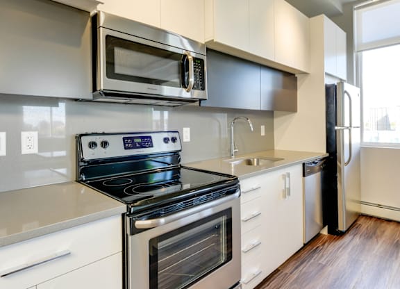 A modern kitchen with a stove, oven, microwave, and refrigerator.