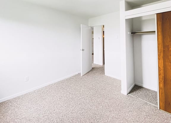 A room with a carpeted floor and a wooden door.