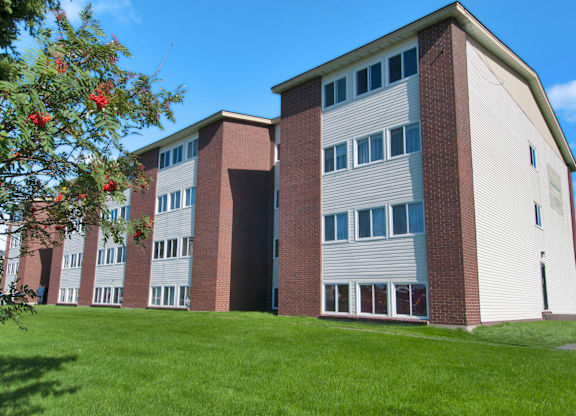 A red and white building with a green lawn in front.