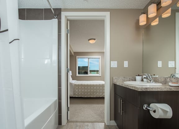 A bathroom with a white shower stall, a sink, and a toilet.