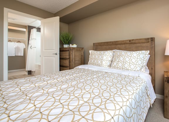 A bedroom with a large bed and a wooden headboard.