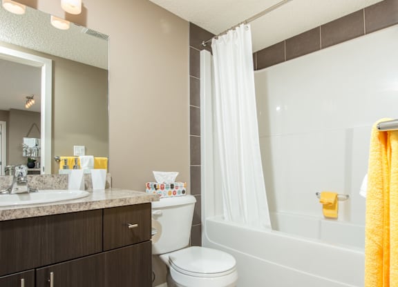 A bathroom with a white toilet, sink, and bathtub.