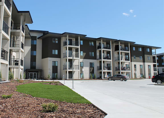 Apartment complex with cars parked in front.