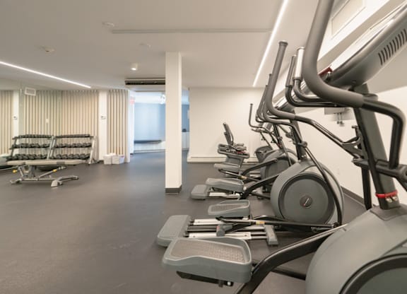 A gym with treadmills and elliptical machines.