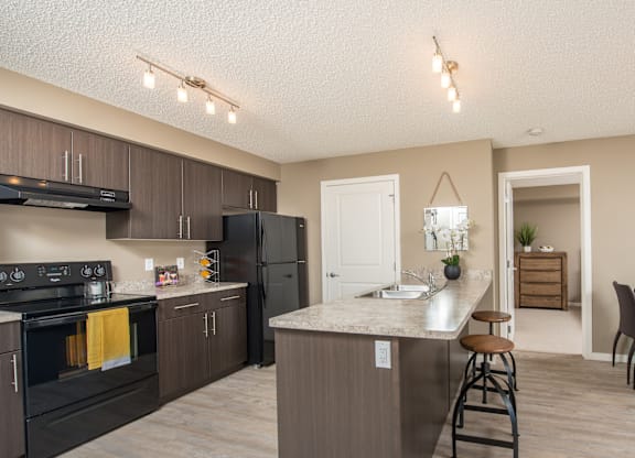 A kitchen with a black stove top oven and a black refrigerator.