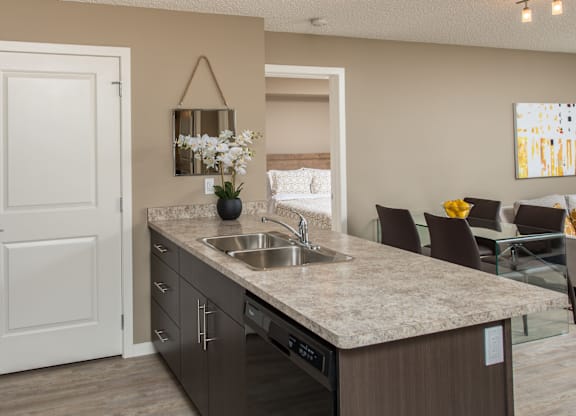 A kitchen with a sink, stove, and a mirror on the wall.