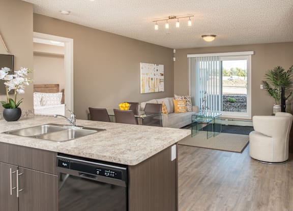 A modern kitchen with a marble countertop and stainless steel appliances.