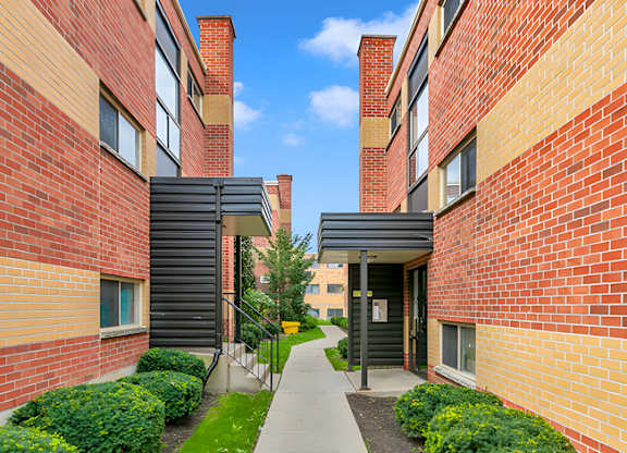 A brick building with a black gate in the middle of a walkway.