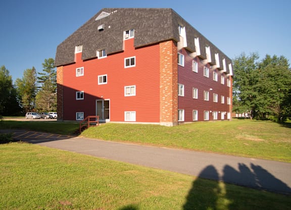 A red brick building with a black roof and white trim.