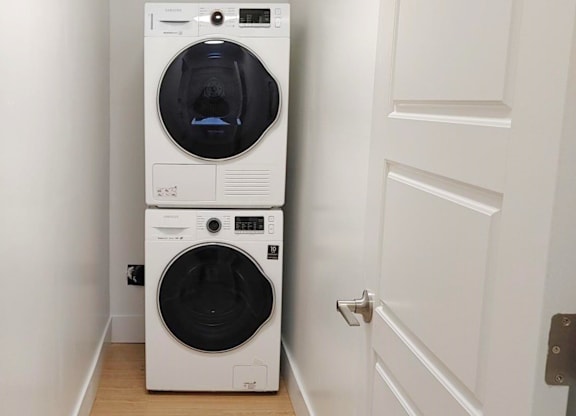 A white front loading washing machine in a small room.