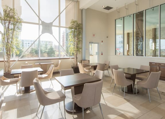 A modern dining room with large windows and a view of the city.