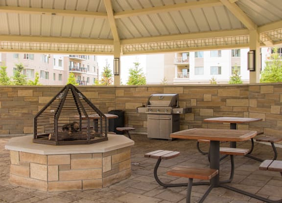 A patio with a fire pit and picnic table.