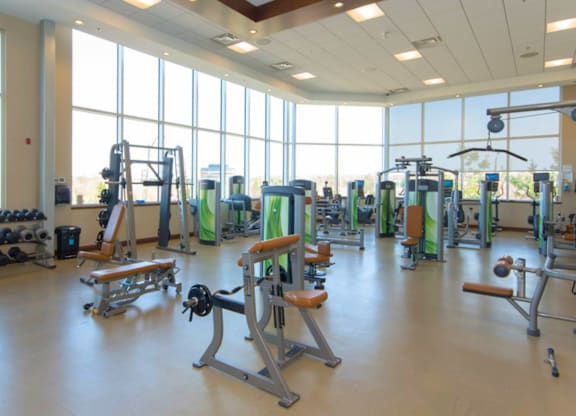 A gym with a variety of equipment including weights and machines.