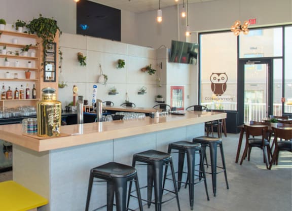 A bar with a yellow stool and a white counter.
