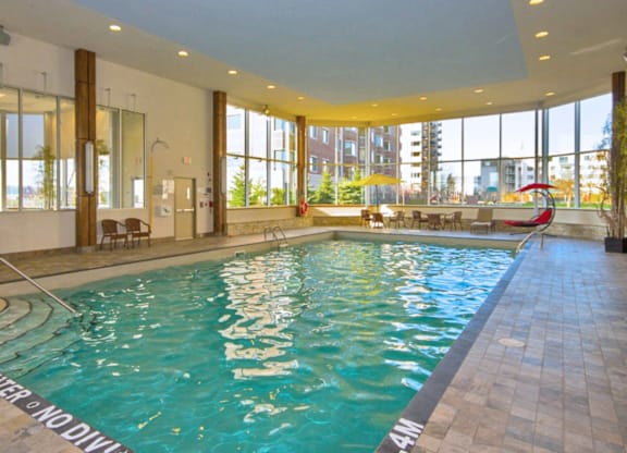 A large indoor swimming pool with a "No Diving" sign.