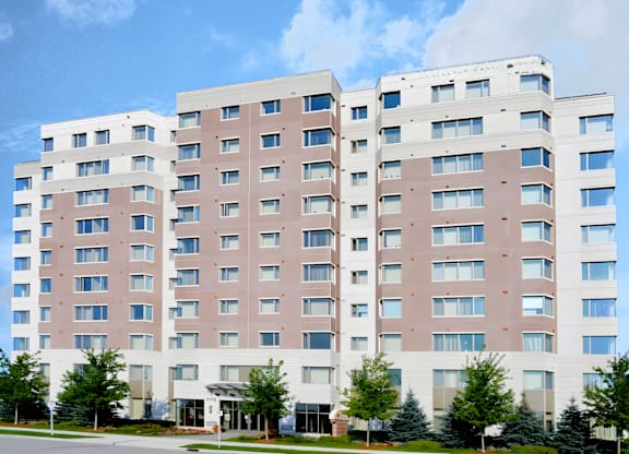 A large, modern building with a white and pink facade and multiple windows.