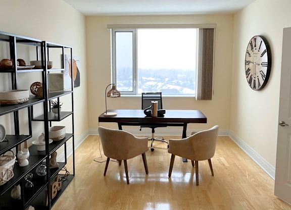 A room with a table, chairs and a shelf with objects on it.