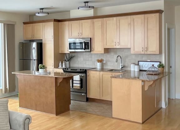 A modern kitchen with wooden cabinets and stainless steel appliances.
