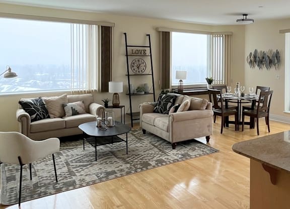 A living room with a large window and a view of the city.