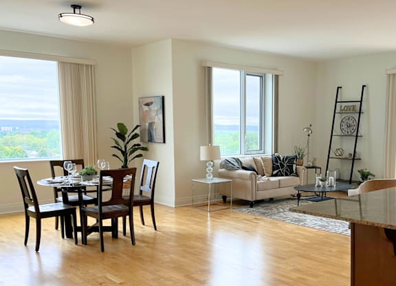 A dining room with a table set for six and a couch in the background.