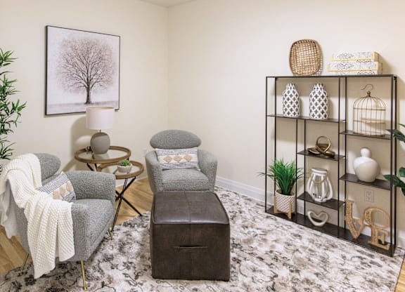 A living room with a grey chair, a small table, and a shelf with decorative items.