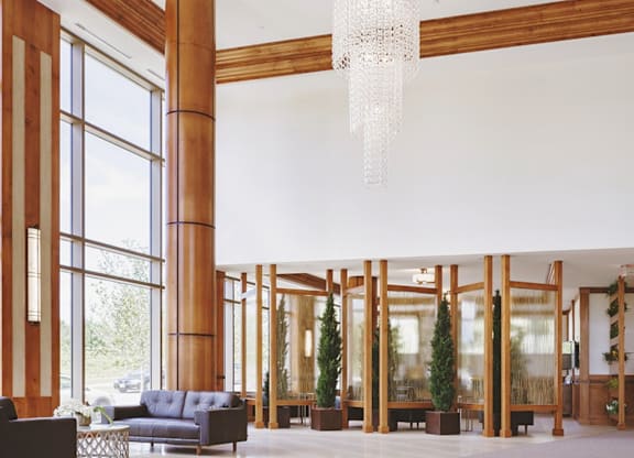 A large room with a blue sofa and a chandelier hanging from the ceiling.