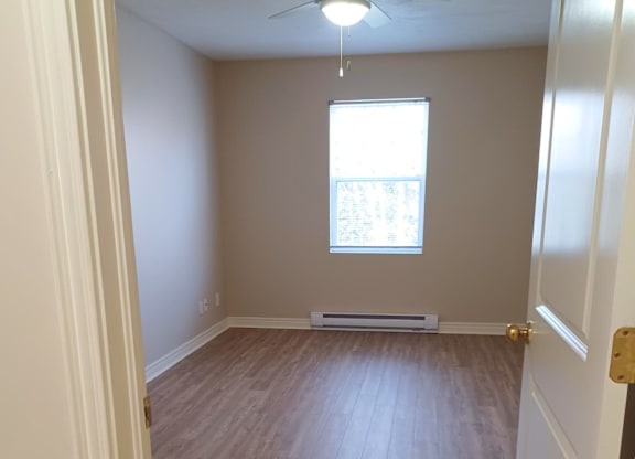 A room with a window and a ceiling fan.
