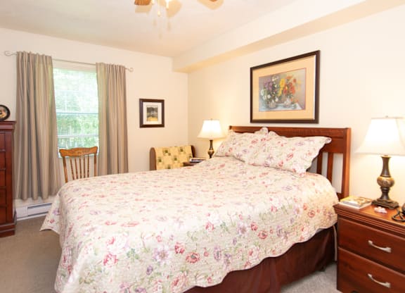 A bedroom with a large bed and a ceiling fan.