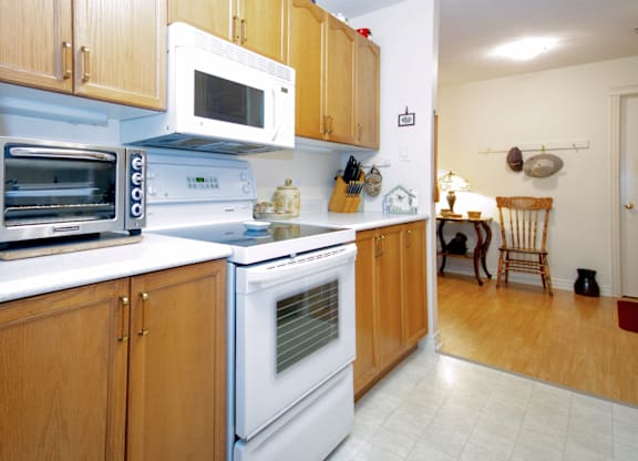 A kitchen with wooden cabinets and white appliances.