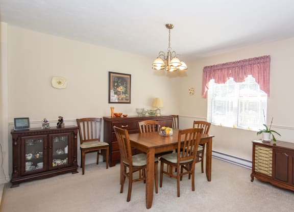 A dining room with a wooden table and chairs.