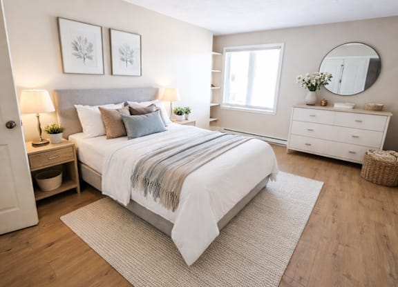 A bedroom with a large bed, a dresser, and a mirror.