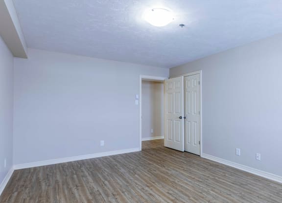 A room with wooden flooring and white walls.
