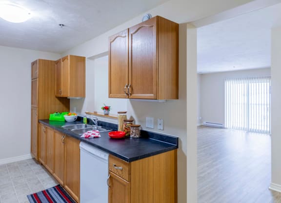 A kitchen with wooden cabinets and a black countertop.