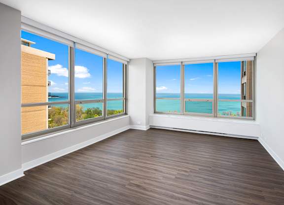 A room with a view of the ocean through large windows.