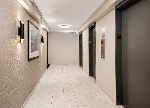 A hallway with a black door on the right and a white door on the left.