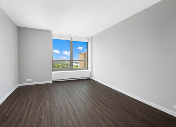 A room with a window overlooking a building.