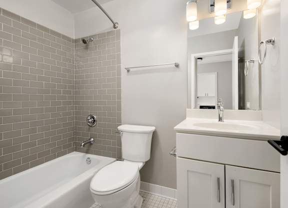 A white toilet sits next to a white sink in a bathroom.