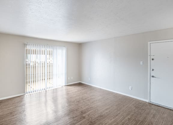 A room with a white door and a window with blinds.
