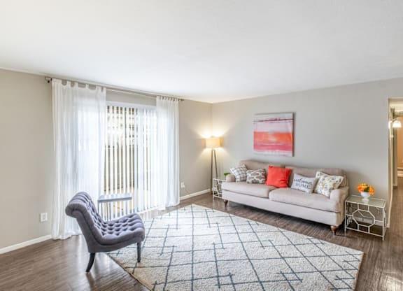 A living room with a grey chair and a white sofa.