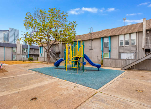 A playground with a blue slide and a yellow slide.
