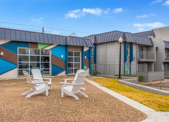 A sunny day at a modern building with white chairs in front.