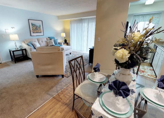 a living room and dining room with a table and chairs  at Hunter's Creek Apartments, Ohio