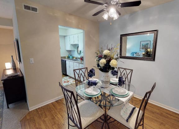 a dining room with a table and chairs and a ceiling fan  at Hunter's Creek Apartments, Cincinnati
